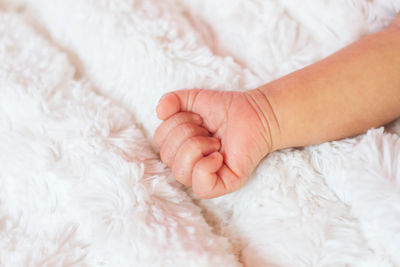 Close-up of baby hand on bed