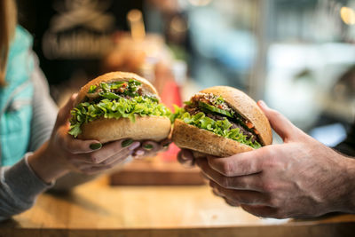 Close-up of couple holding hamburgers