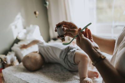 Mother giving syrup medicine to baby