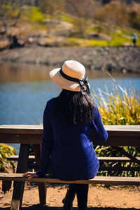 Rear view of woman sitting on bench