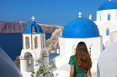 Rear view of woman standing by church