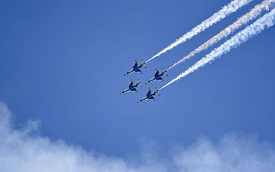 Low angle view of airshow against sky