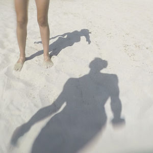 Low section of people standing on beach