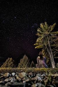 Low angle view of trees on field against sky at night