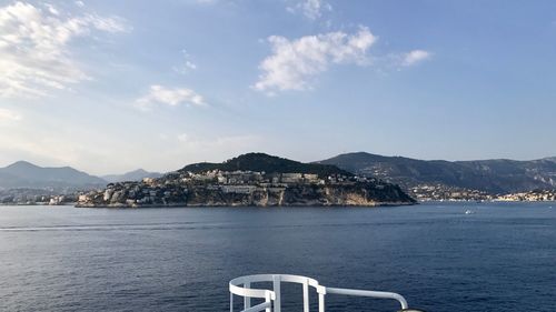 Scenic view of sea by mountains against sky