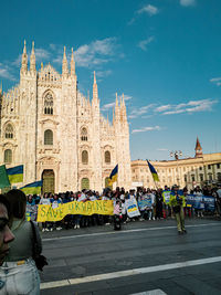 Rear view of people in front of historic building