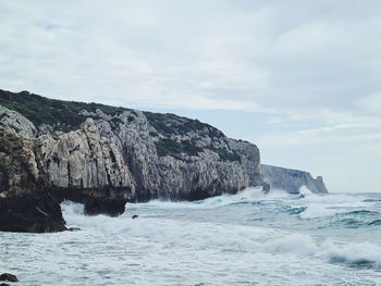 Rock formations by sea against sky