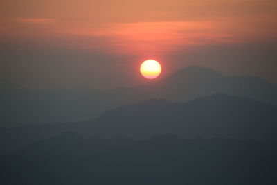 Scenic view of silhouette mountains against romantic sky at sunset