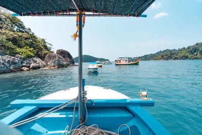 Boats moored in sea against sky