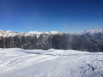 Scenic view of snowcapped mountains against clear blue sky