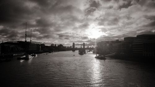 View of boats in river against cloudy sky