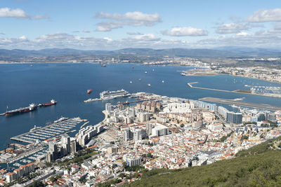 High angle view of city by sea against sky