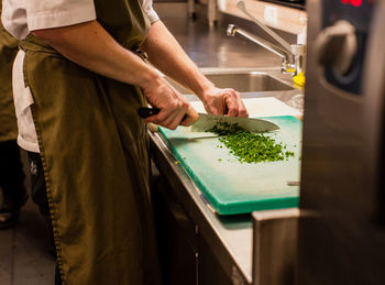 Midsection of man preparing food in kitchen