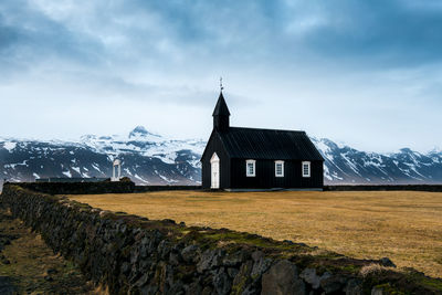 Built structure on snowcapped mountain against sky