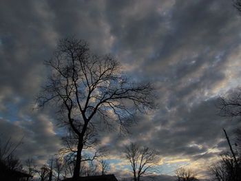 Low angle view of bare tree against cloudy sky