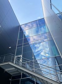 Low angle view of glass building against sky