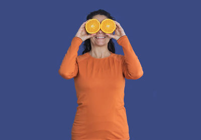 Woman standing against blue background