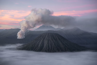 Smoke emitting from volcanic mountain against sky