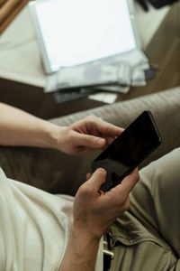 Midsection of man using mobile phone