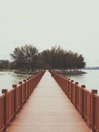 Pier over river against clear sky