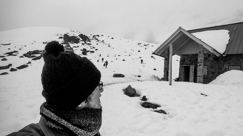 Man with pigeons on snow against sky