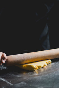 Midsection of person rolling dough