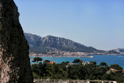 Scenic view of sea and mountains against clear sky