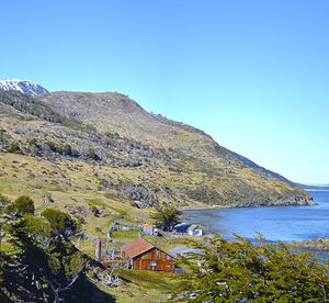 Scenic view of sea and buildings against clear blue sky