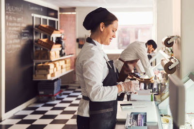 Side view of owners working at counter in grocery store