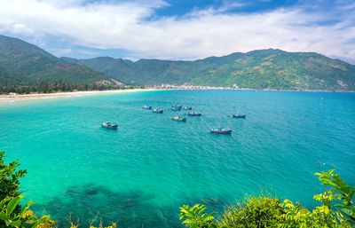 Scenic view of bay and mountains against sky