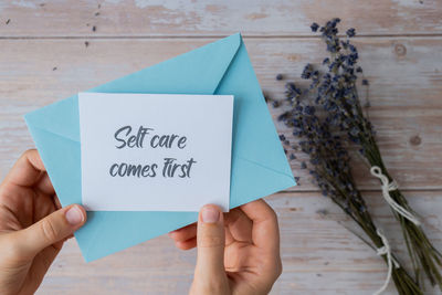 Cropped hand of person writing on adhesive note