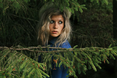 Portrait of young woman against plants