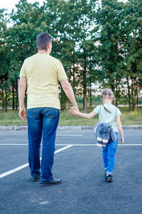 Rear view of father and son standing on tree