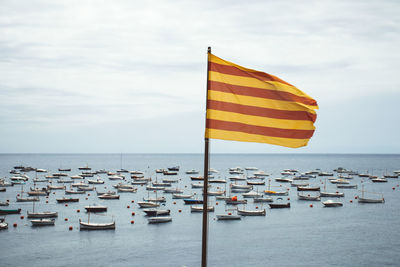 Flags on sea against sky