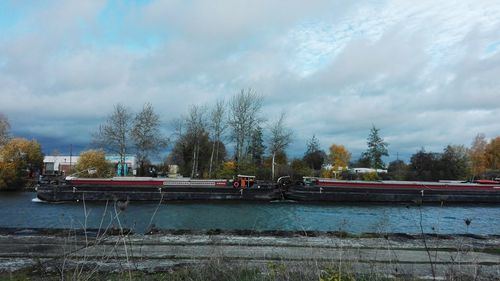 Boats moored on river against sky