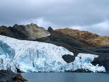 Scenic view of lake against frozen mountains