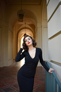 Young woman standing against wall