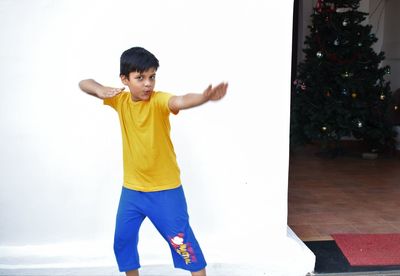 Boy standing by christmas tree at home