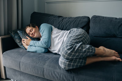 Portrait of young woman sitting on sofa at home