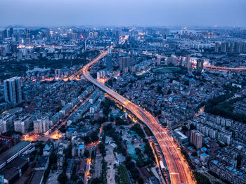 Aerial view of bridge amidst cityscape at dusk