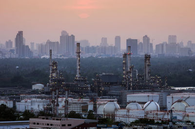 View of buildings in city during sunset oil refinery