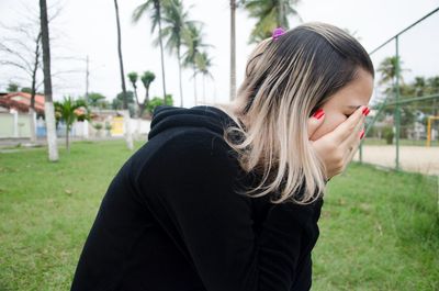 Side view of young woman on field