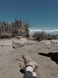 Low section of woman on land against sky