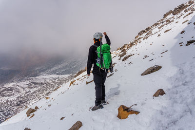 Rear view of people walking on snow covered mountain