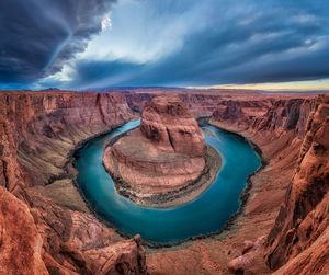 Scenic view of horseshoe bend against cloudy sky