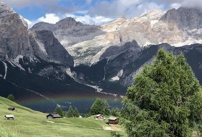 Rainbow on a dolomite landscape with little mountain huts