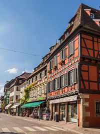 Street by buildings against blue sky