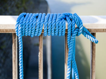 Close-up of blue rope tied on railing