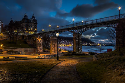 Illuminated bridge over street at scarborough against sky