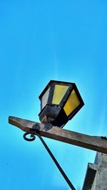 Low angle view of street light against blue sky